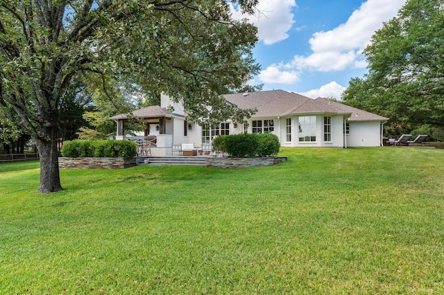 rear view of property featuring a lawn and a gazebo