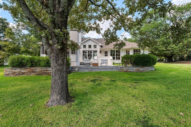 back of property featuring stucco siding and a yard