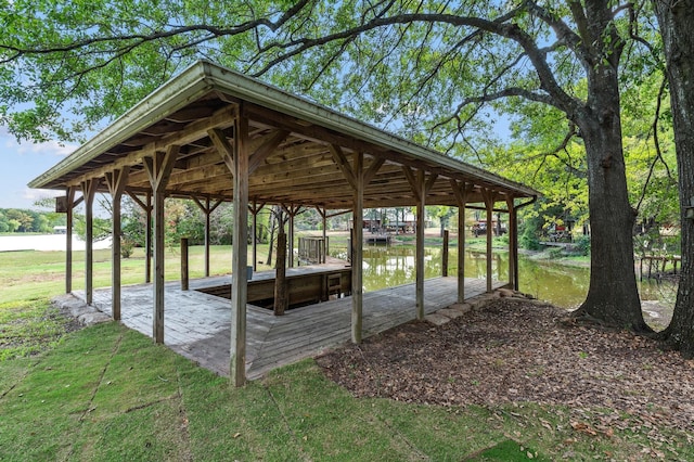 view of dock with a yard and a water view