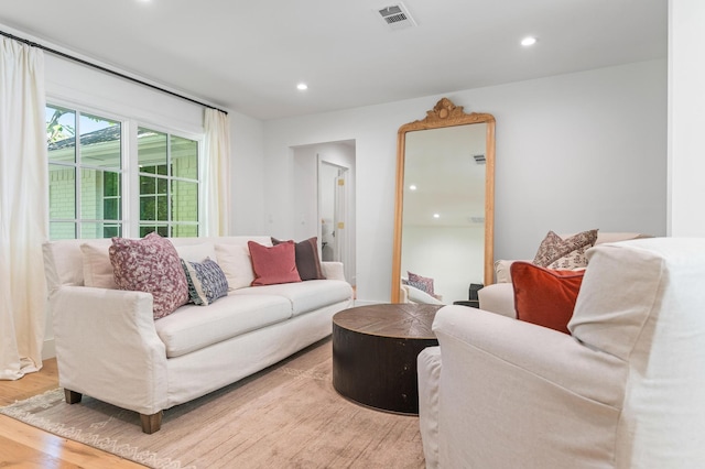 living area featuring recessed lighting, visible vents, and wood finished floors