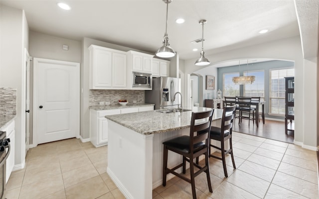 420 Westminster Dr, Lewisville, TX 75056 - kitchen featuring appliances with stainless steel finishes, a sink, arched walkways, tasteful backsplash, and visible vents