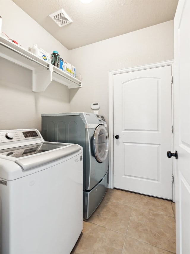 420 Westminster Dr, Lewisville, TX 75056 - laundry area featuring light tile patterned floors, visible vents, laundry area, and washing machine and clothes dryer