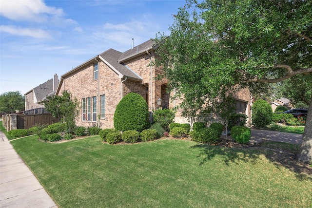 420 Westminster Dr, Lewisville, TX 75056 - traditional home featuring fence, an attached garage, a front lawn, brick siding, and driveway