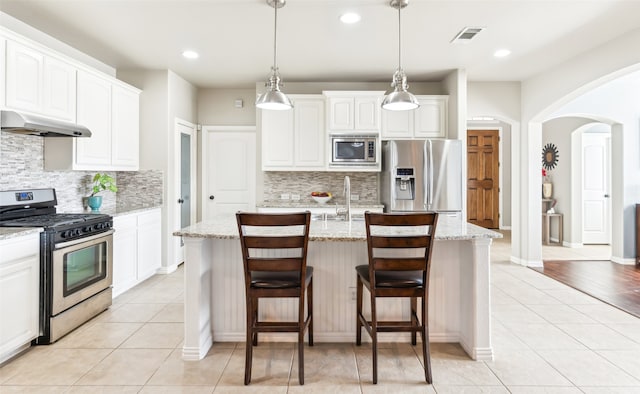 420 Westminster Dr, Lewisville, TX 75056 - kitchen featuring visible vents, a sink, under cabinet range hood, arched walkways, and stainless steel appliances