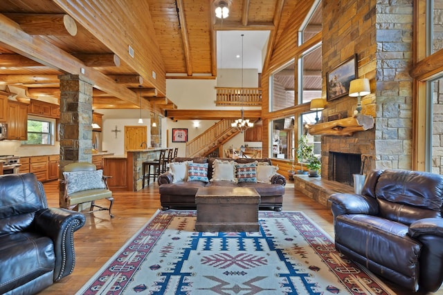 living room with wood ceiling, light wood finished floors, beamed ceiling, and a notable chandelier