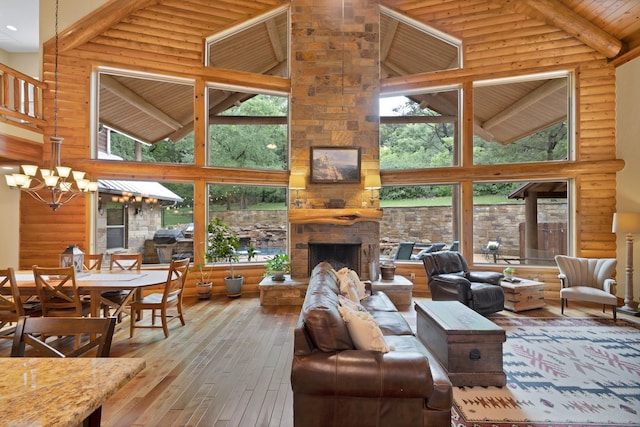 living room featuring high vaulted ceiling, hardwood / wood-style flooring, a wealth of natural light, and a notable chandelier