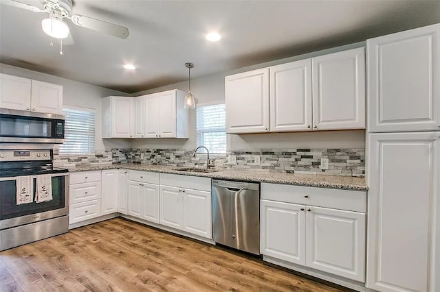 605 N Snyder Ave, Justin, TX 76247 - kitchen featuring appliances with stainless steel finishes, white cabinetry, ceiling fan, light wood finished floors, and recessed lighting