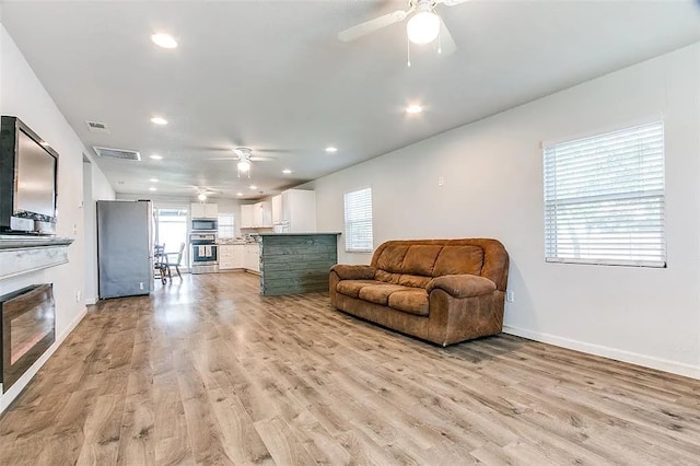 living room with baseboards, visible vents, a ceiling fan, and recessed lighting