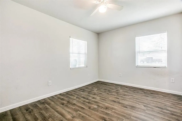 empty room featuring baseboards, ceiling fan, and dark wood-type flooring