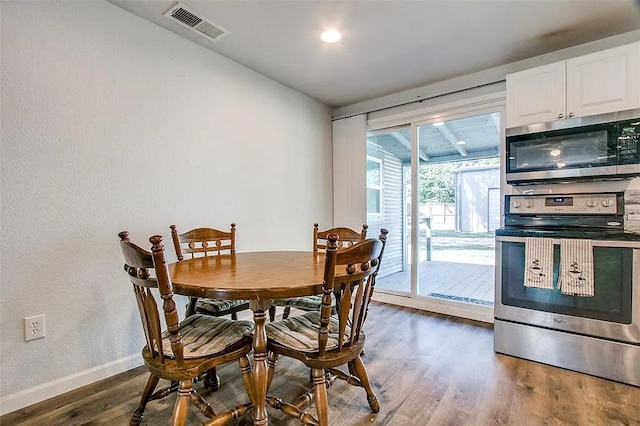 dining space featuring dark wood finished floors, visible vents, and baseboards
