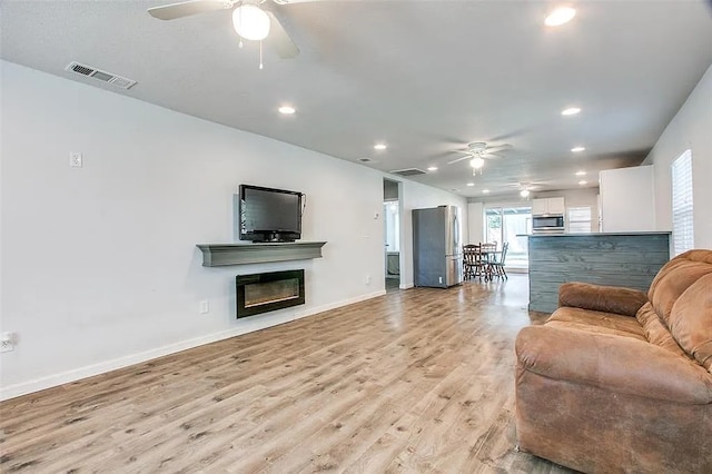 living area featuring light wood finished floors, ceiling fan, recessed lighting, and visible vents