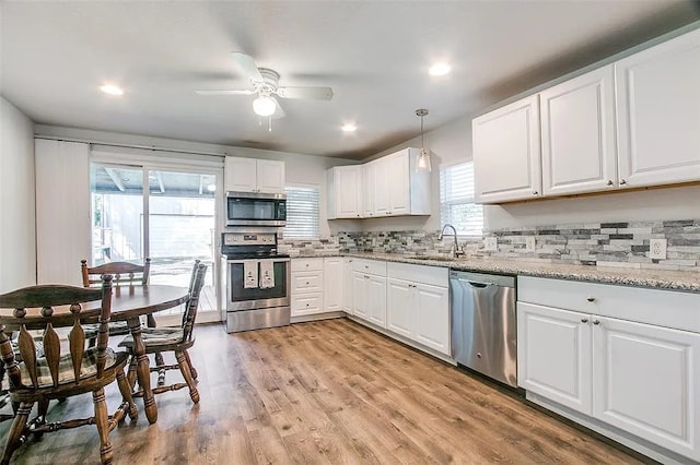 kitchen with white cabinetry, stainless steel appliances, a ceiling fan, and a sink