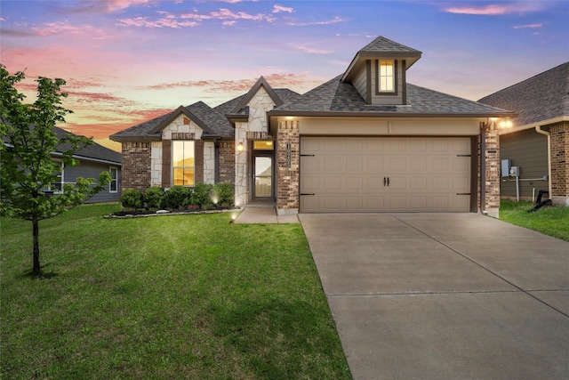 french country home with roof with shingles, stone siding, driveway, a garage, and a front yard