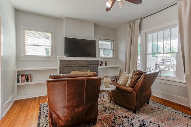 4621 Pershing Ave, Fort Worth, TX 76107 - living area featuring a fireplace, ceiling fan, light wood-style flooring, and baseboards