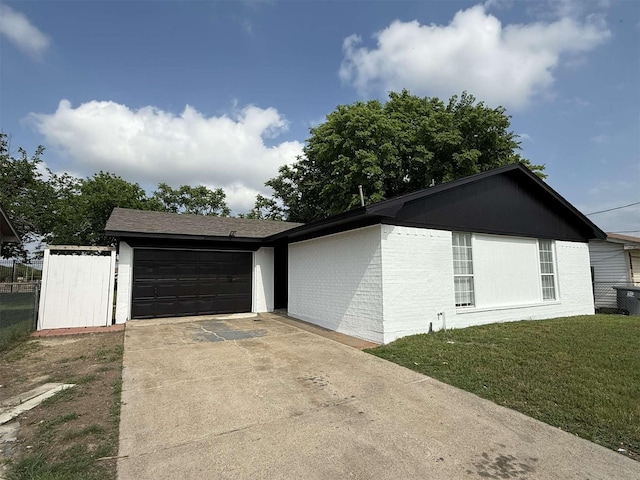 2726 Kellogg Ave, Dallas, TX 75216 - view of home's exterior featuring driveway, fence, a yard, brick siding, and a garage