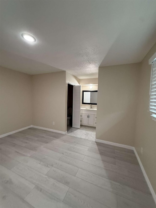 2726 Kellogg Ave, Dallas, TX 75216 - spare room featuring light wood finished floors, a sink, and baseboards