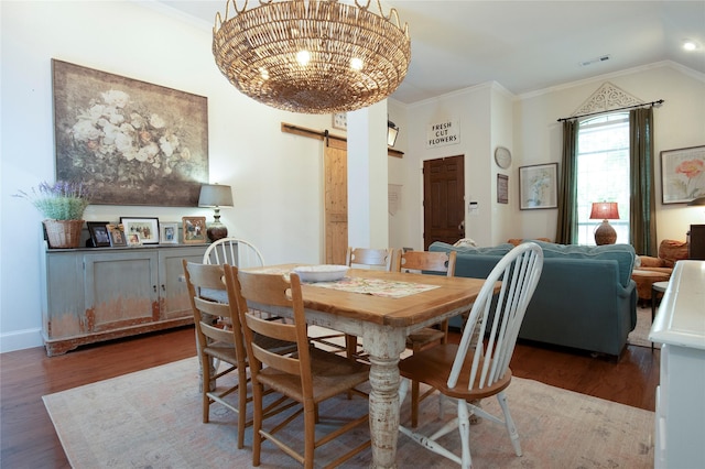 2621 Timberhollow Dr, Little Elm, TX 75068 - dining area with crown molding, a barn door, visible vents, wood finished floors, and a notable chandelier