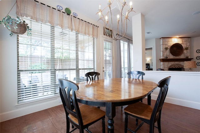 2621 Timberhollow Dr, Little Elm, TX 75068 - dining space featuring an inviting chandelier, wood finished floors, a stone fireplace, and baseboards