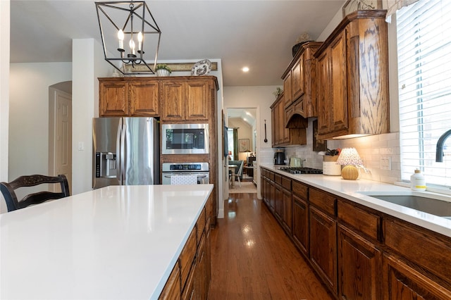2621 Timberhollow Dr, Little Elm, TX 75068 - kitchen with decorative backsplash, appliances with stainless steel finishes, light countertops, dark wood-style flooring, and a sink