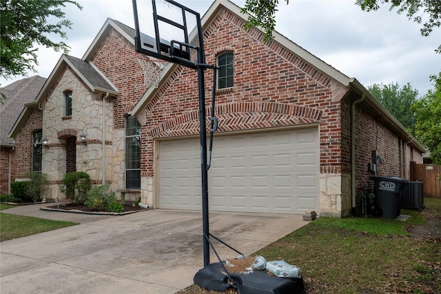 2621 Timberhollow Dr, Little Elm, TX 75068 - view of side of property featuring driveway, cooling unit, stone siding, an attached garage, and brick siding