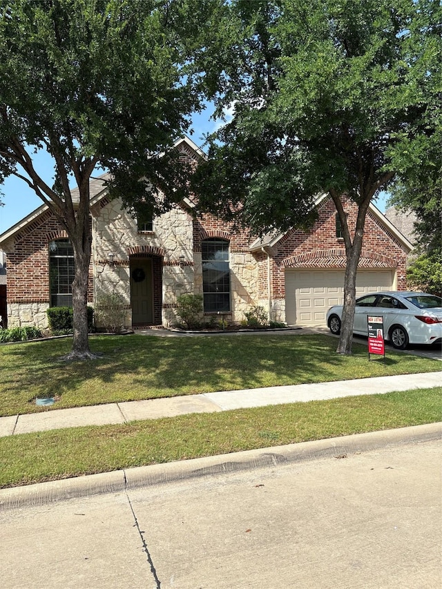 2621 Timberhollow Dr, Little Elm, TX 75068 - view of front of house with a front lawn, stone siding, an attached garage, and brick siding
