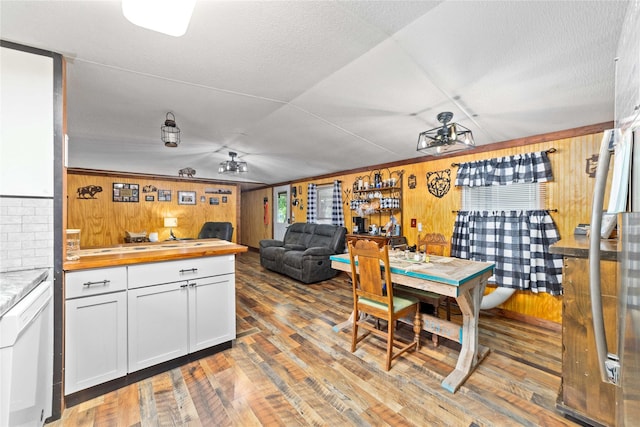 4991 Thunderbird Dr, May, TX 76857 - kitchen featuring wooden counters, wood walls, wood finished floors, and white cabinetry