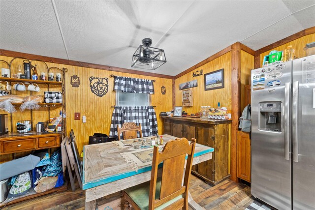 4991 Thunderbird Dr, May, TX 76857 - dining area featuring wood finished floors, wooden walls, and a textured ceiling