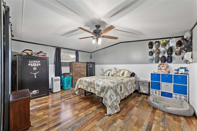 4991 Thunderbird Dr, May, TX 76857 - bedroom featuring ceiling fan, a wainscoted wall, vaulted ceiling, a textured ceiling, and wood finished floors