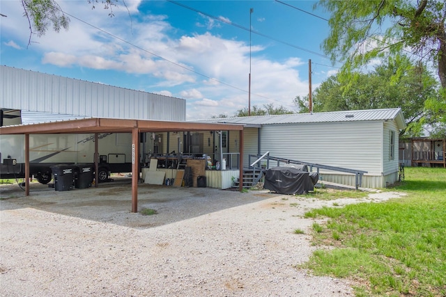 4991 Thunderbird Dr, May, TX 76857 - rear view of house featuring driveway, metal roof, and an attached carport