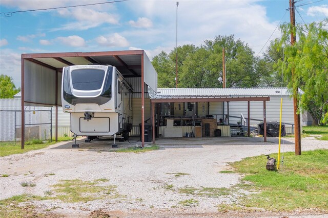 4991 Thunderbird Dr, May, TX 76857 - exterior space featuring metal roof, gravel driveway, a detached carport, and fence