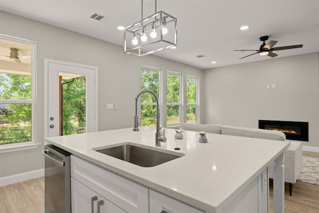 206 Splitrail Dr, Mabank, TX 75143 - kitchen with stainless steel dishwasher, a sink, a healthy amount of sunlight, open floor plan, and light wood finished floors