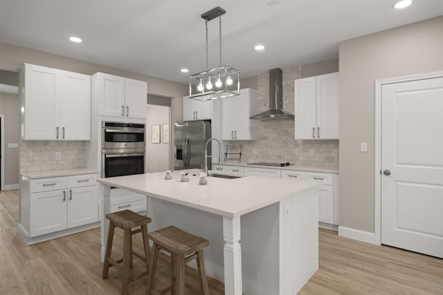 206 Splitrail Dr, Mabank, TX 75143 - kitchen with tasteful backsplash, a sink, light wood-style floors, stainless steel appliances, and wall chimney exhaust hood