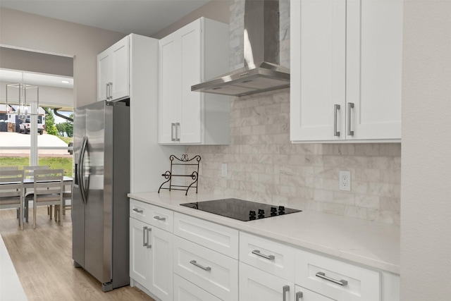 206 Splitrail Dr, Mabank, TX 75143 - kitchen featuring light wood-style floors, wall chimney range hood, black electric cooktop, white cabinets, and stainless steel refrigerator with ice dispenser