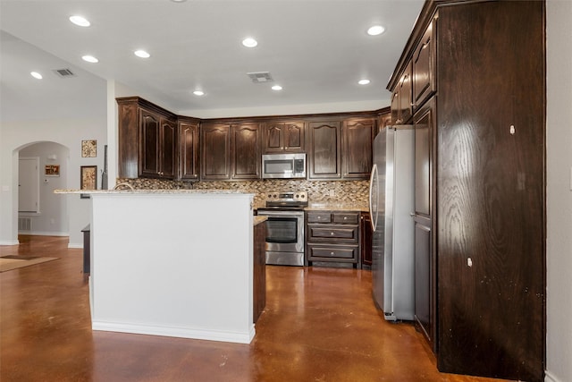 516 Celeste Dr, Robinson, TX 76706 - kitchen with appliances with stainless steel finishes, concrete flooring, arched walkways, decorative backsplash, and dark brown cabinets