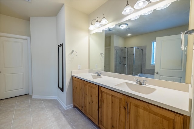 full bath with double vanity, a stall shower, tile patterned flooring, and a sink