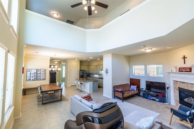 living room featuring visible vents, light tile patterned floors, ceiling fan with notable chandelier, and plenty of natural light