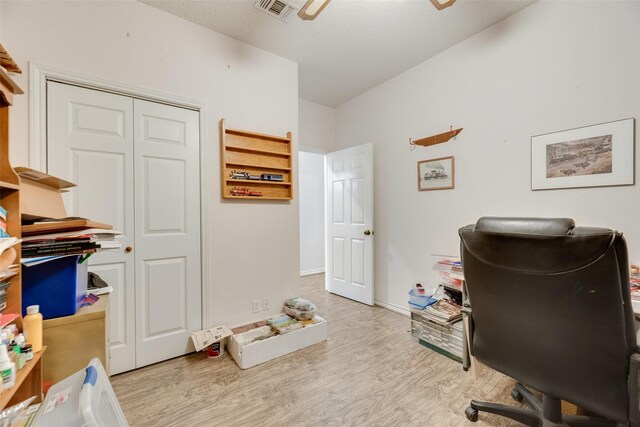 home office featuring baseboards, a textured ceiling, wood finished floors, and visible vents