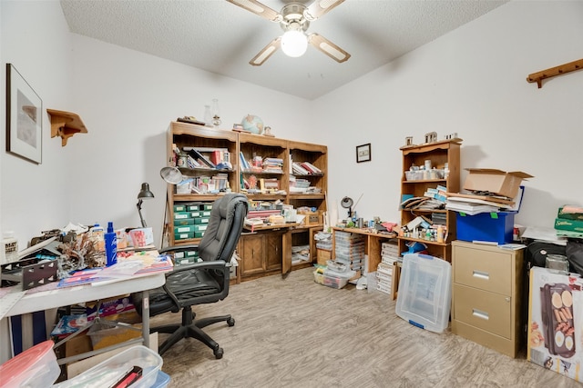 office area featuring light wood-style floors, ceiling fan, a textured ceiling, and lofted ceiling