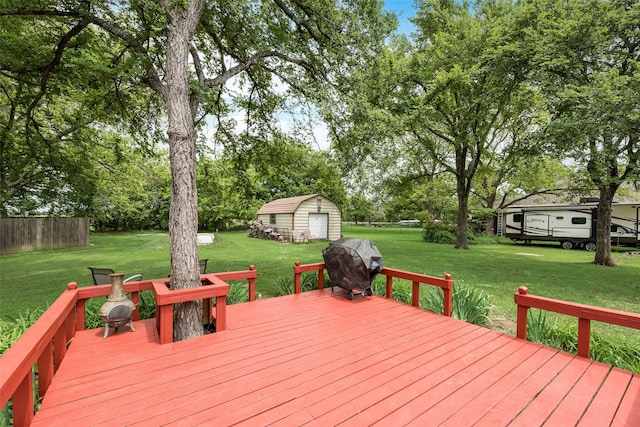wooden deck featuring a storage shed, a lawn, an outdoor structure, and area for grilling