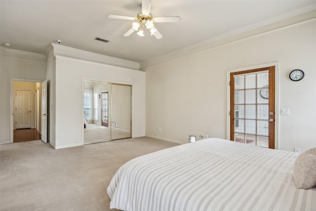 bedroom with visible vents, crown molding, a closet, light carpet, and baseboards
