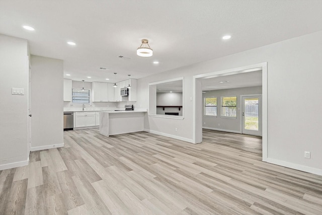 4302 Ashville Dr, Garland, TX 75041 - unfurnished living room with light wood-style floors, baseboards, and recessed lighting