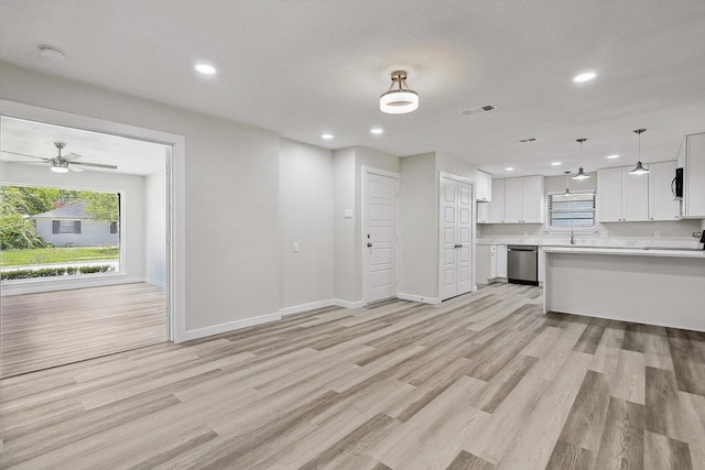 unfurnished living room featuring visible vents, light wood-style flooring, and plenty of natural light