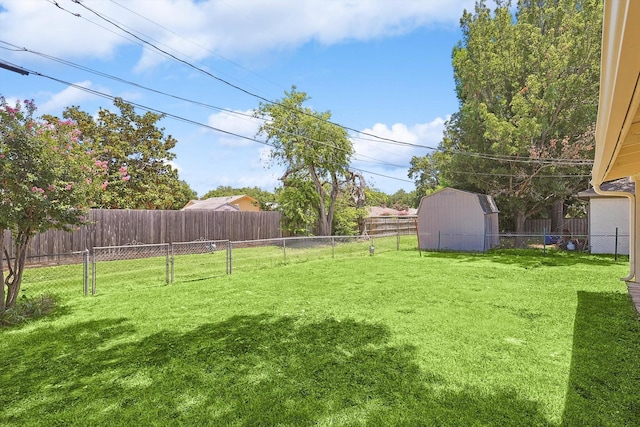 view of yard with an outbuilding, a shed, and a fenced backyard