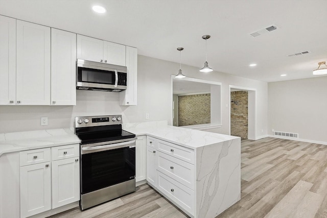 kitchen with a peninsula, visible vents, and appliances with stainless steel finishes