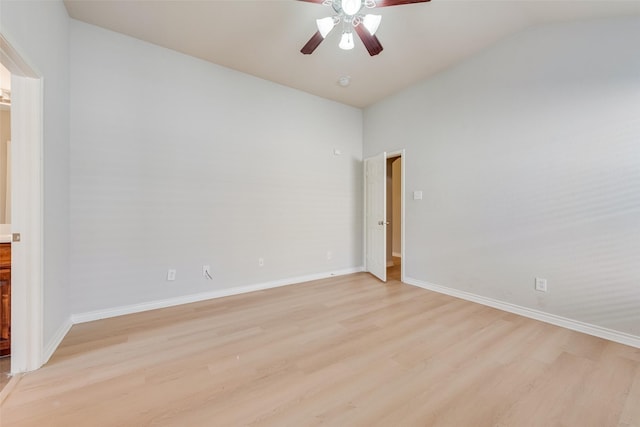 spare room featuring lofted ceiling, a ceiling fan, light wood finished floors, and baseboards