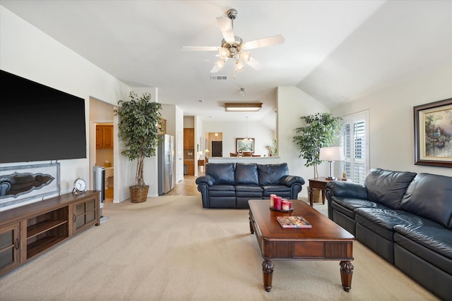 living area featuring visible vents, a ceiling fan, light carpet, and vaulted ceiling