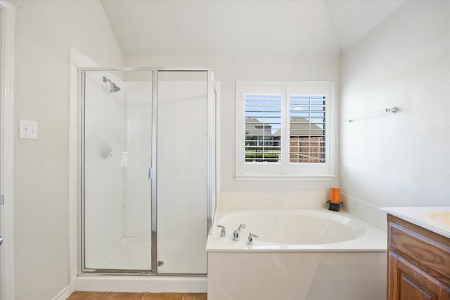 bathroom with a bath, a stall shower, lofted ceiling, and vanity