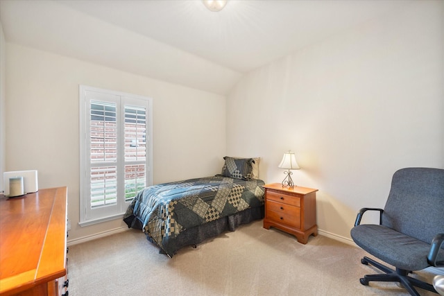 carpeted bedroom featuring lofted ceiling and baseboards