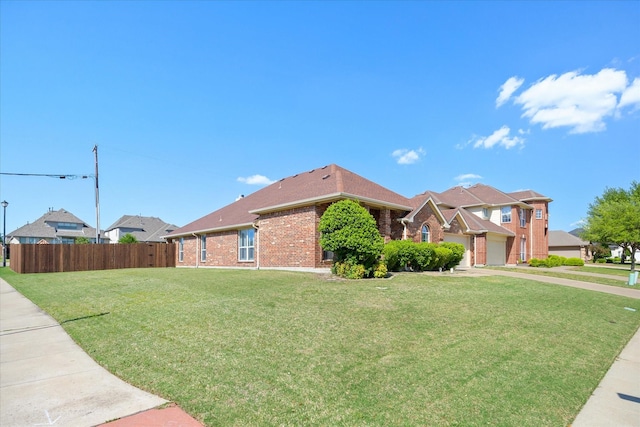 view of side of property featuring fence, a lawn, and brick siding