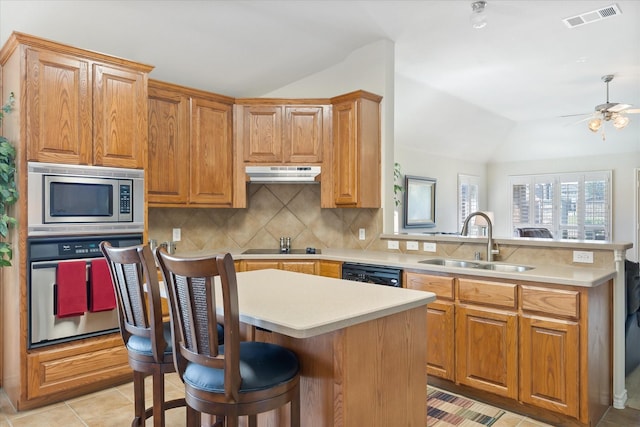 kitchen featuring a sink, under cabinet range hood, black appliances, visible vents, and lofted ceiling